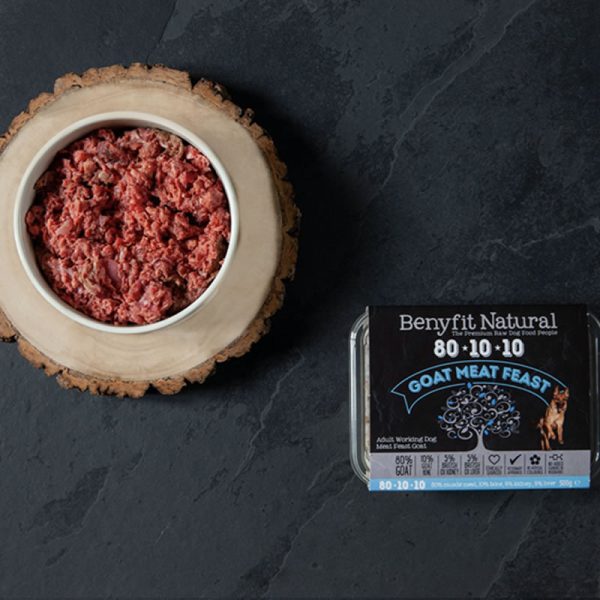 The Benyfit Natural Goat Meat Feast packaging alongside a dog bowl filled with the product.